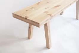 A cropped photograph of a bespoke pine timber bench on a white background.