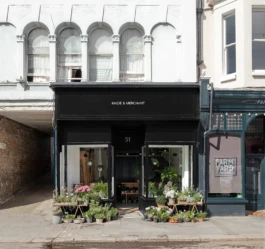 A renovated Victorian shop, now a florist with plants displayed outside and a black painted shopfront.