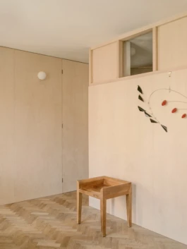 A house interior with parquet flooring and birch plywood timber panelling on the walls.