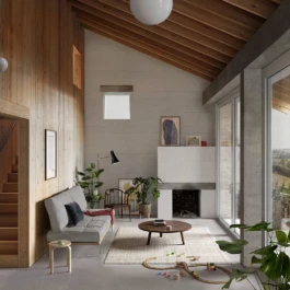 A double height living room with a fireplace, sofa and large windows with views to hills outside.