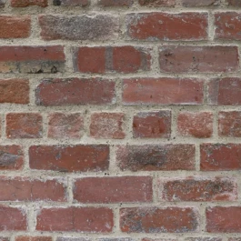 A close, zoom view of a historic, red brick wall.