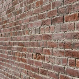 An angled, zoom view of a historic, red brick wall.