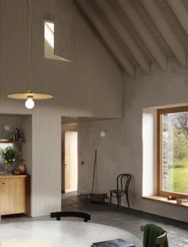 A house interior with a high ceiling, lime plaster walls and a window to the garden.