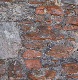 A zoom photograph of a natural stone and rock wall finished with lime mortar.