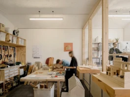 A workshop studio space with people making architectural models.