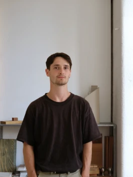 Photograph of staff member standing next to a shelf with architectural models and materials