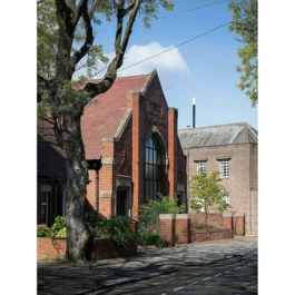 A church converted into a home. The facade is red brick with a garden at the front. 